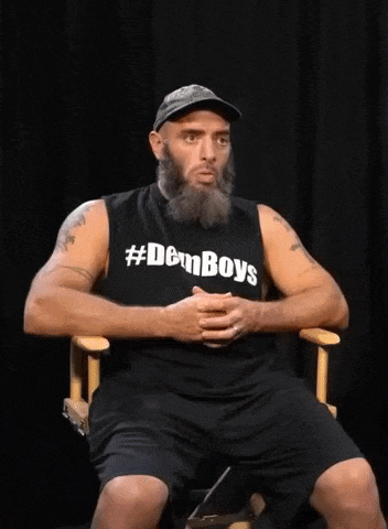 a man with a beard wearing a #demboys shirt