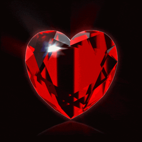 a red heart with a black background is glowing in the dark