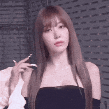 a woman with long hair is wearing a black strapless top