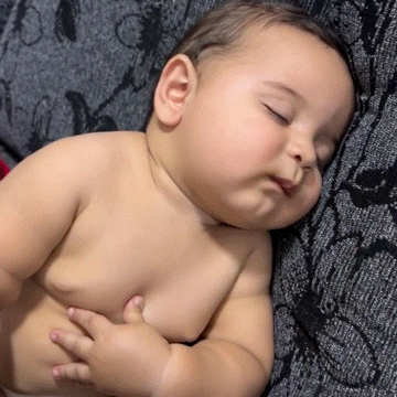a baby is sleeping on a pillow with his eyes closed