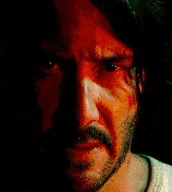 a close up of a man 's face with a beard and red eyes