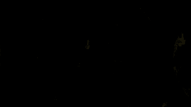 two women are standing next to each other in a dark room . one of the women is holding a knife in her hand .