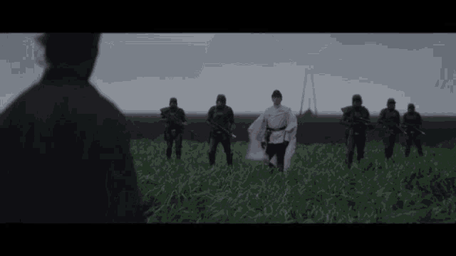 a group of soldiers are standing in a grassy field and one of them is holding a flag