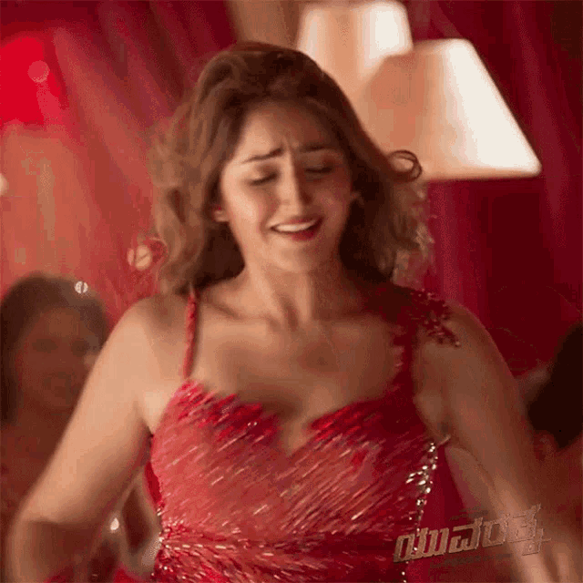 a woman in a red dress is dancing in front of a lamp .