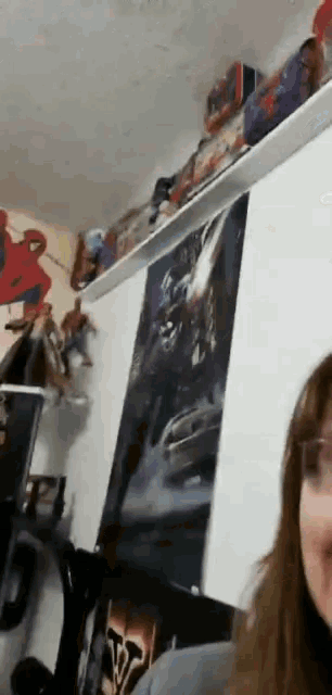 a woman is sitting in front of a shelf with toys on it