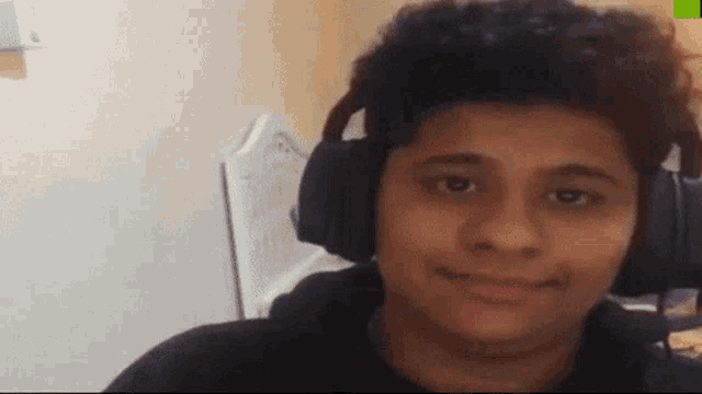 a man wearing headphones looks at the camera and smiles