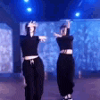 two women are dancing in a room with blue lights .