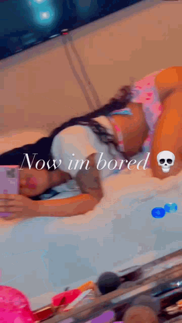 a woman is laying on a bed with a skull on her arm .