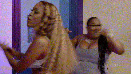 two women are standing next to each other in a room dancing .