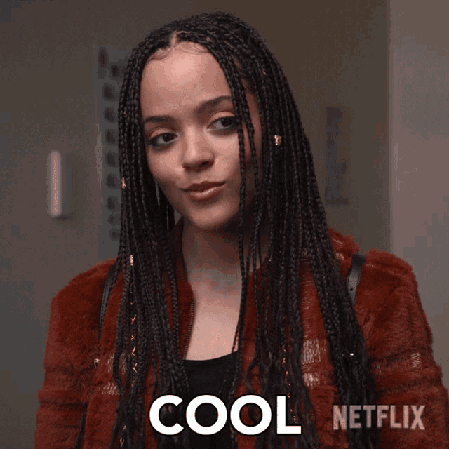 a woman with braids is wearing a red jacket and the word cool is on the bottom right