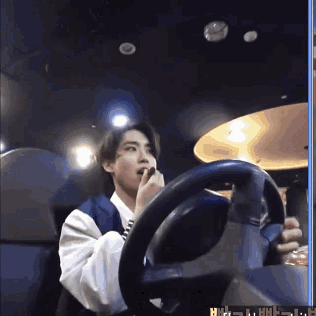 a man is driving a car and applying lipstick to his lips