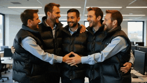 a group of men wearing black vests are hugging