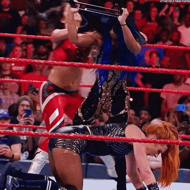 two women are wrestling in a wrestling ring and one of them is wearing a black outfit