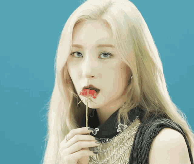 a woman holds a red rose in her mouth