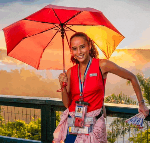 a woman holding a red umbrella with a lanyard around her neck with a name tag that says ' amanda '