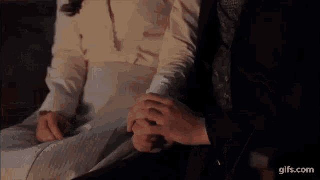 a man and woman are holding hands in a room .