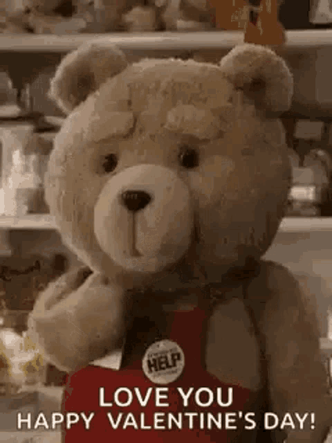 a teddy bear wearing a red apron is holding a box of chocolates .