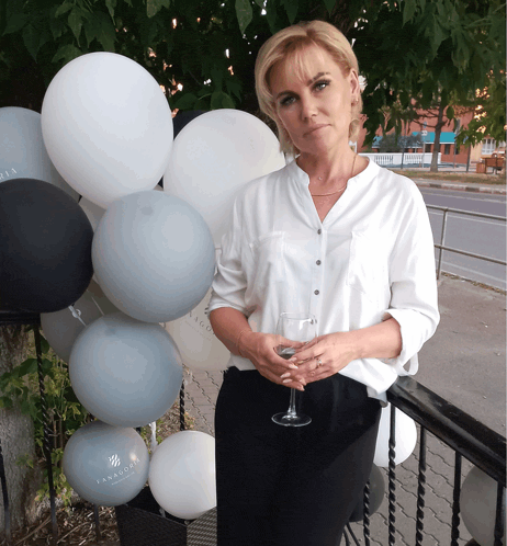 a woman stands in front of a bunch of balloons one of which says ' familia '