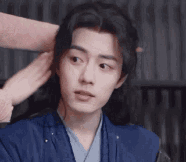 a close up of a person touching a man 's hair .