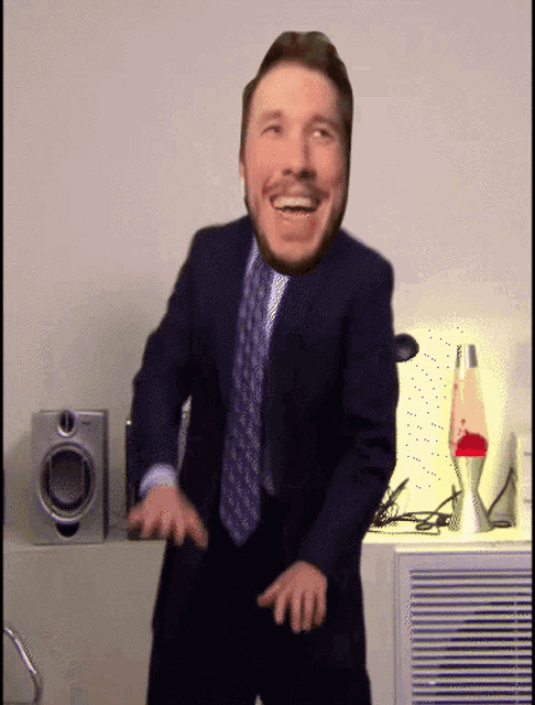 a man in a suit and tie is dancing in front of speakers and a lava lamp