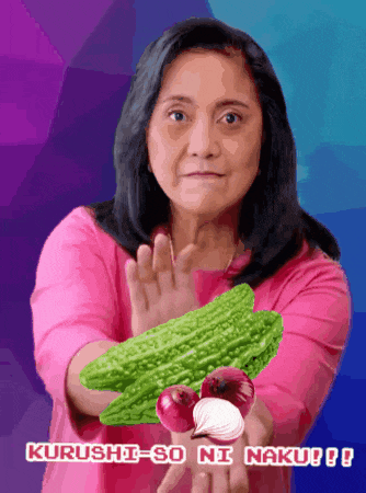 a woman in a pink shirt is holding vegetables and says " kurushi-so ni naku !! "