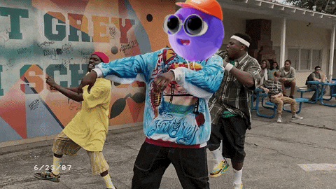 a group of people are dancing in front of a wall that says grey