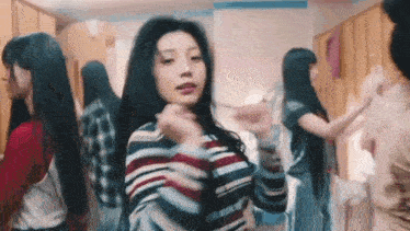 a group of young women are dancing in a locker room and looking at the camera .