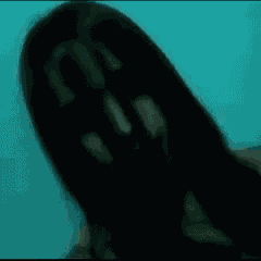 a woman with long black hair is taking a selfie in front of a blue background .