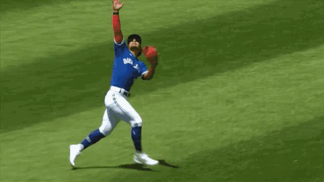 a baseball player wearing a blue jays jersey catching a ball