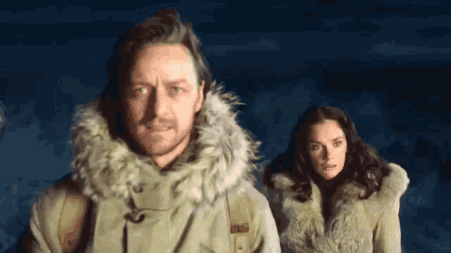 a man and a woman are standing next to each other in a dark room