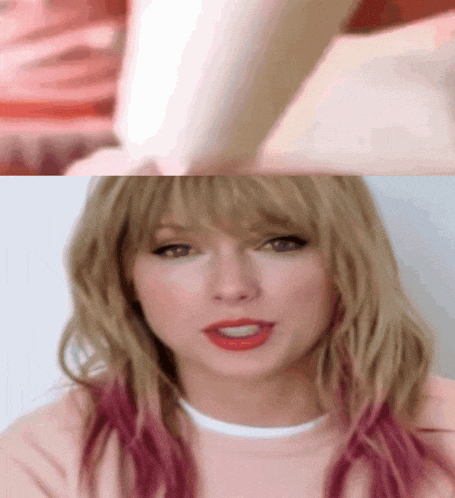 a woman with blonde hair and pink highlights is wearing a pink sweatshirt