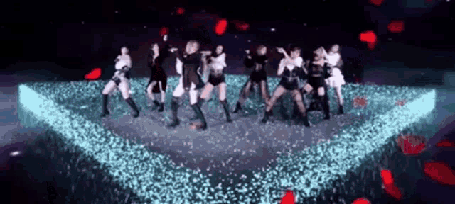 a group of women are dancing on a stage in front of a projector screen .