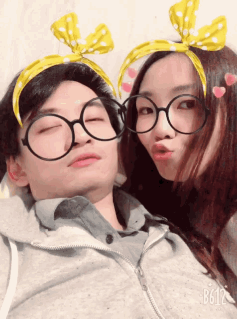 a man and a woman wearing glasses and a headband with the number b612 on the bottom