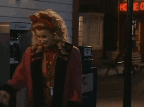 a woman standing in front of a phone booth