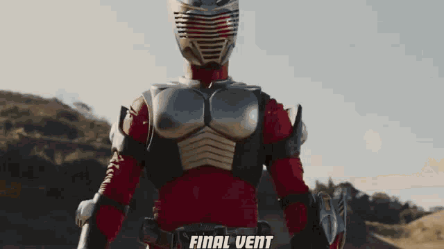 a man in a superhero costume is standing in a field holding a gun .