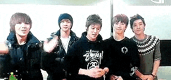 a group of young men are standing next to each other in front of a white board .