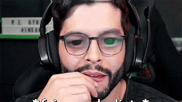 a man with glasses and a beard wearing a headset