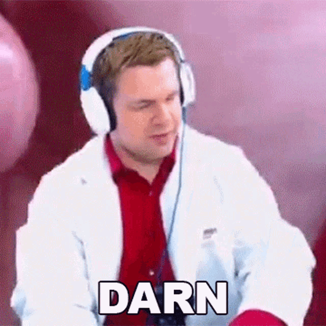 a man wearing headphones and a lab coat is making a funny face and says darn .