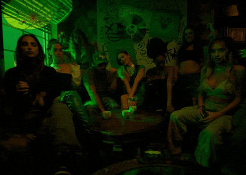 a group of people are sitting around a table in a dark room