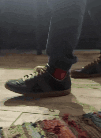 a close up of a person 's feet wearing black shoes