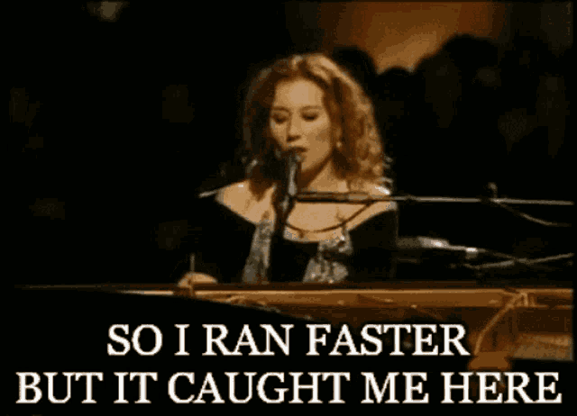 a woman singing into a microphone with the words so i ran faster but it caught me here underneath her