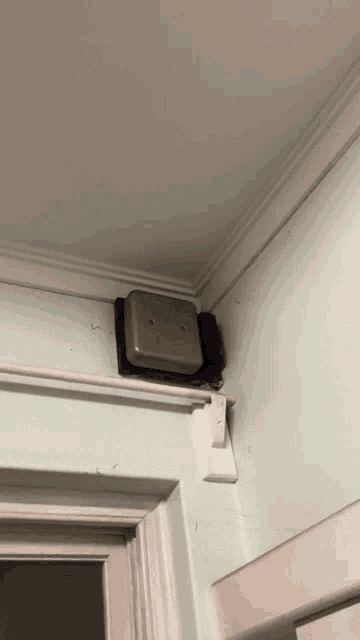 a doorbell is mounted to a wall above a door