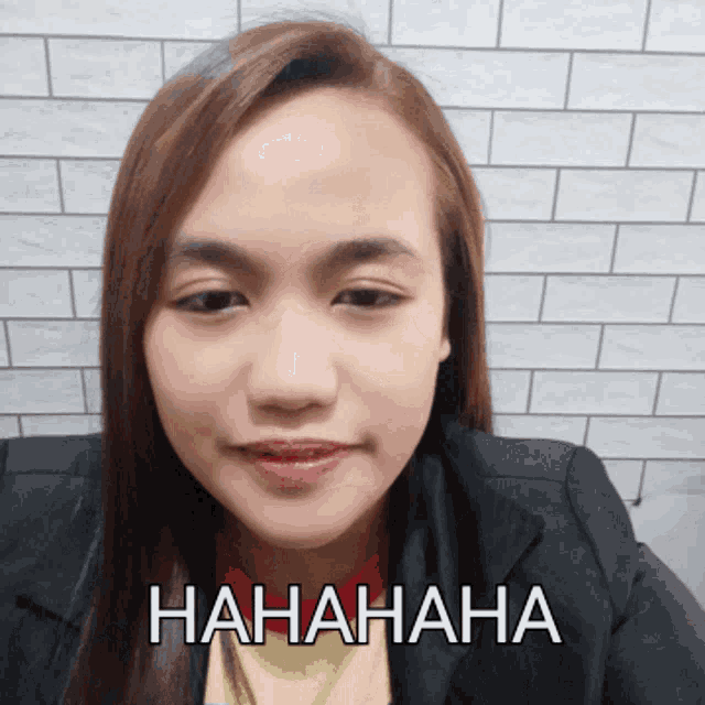 a woman wearing a black jacket and a yellow shirt is laughing with the word  hahaha written on the bottom