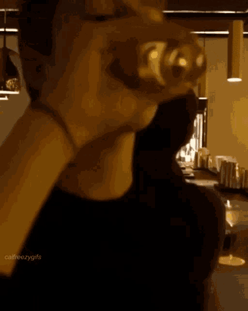 a man is drinking from a bottle in a restaurant