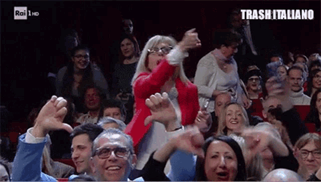 a woman in a red jacket is dancing in a crowd with trash italiano written on the bottom of the screen