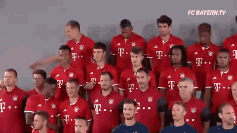 a group of soccer players wearing red t-mobile jerseys