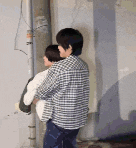 a man in a plaid shirt is carrying another man on his shoulders .
