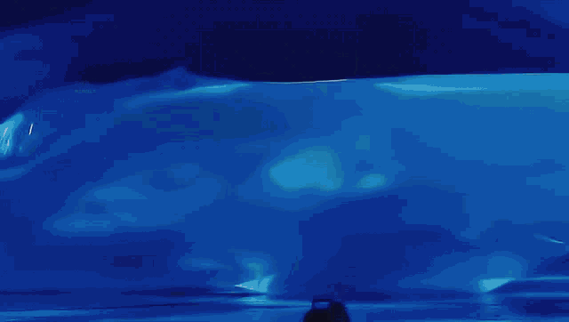 a painting of a person standing in front of a blue iceberg