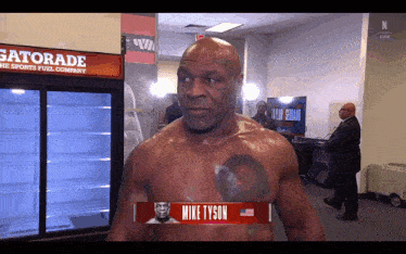a shirtless mike tyson is standing in front of a gatorade cooler