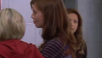 two women are talking to each other in a room .